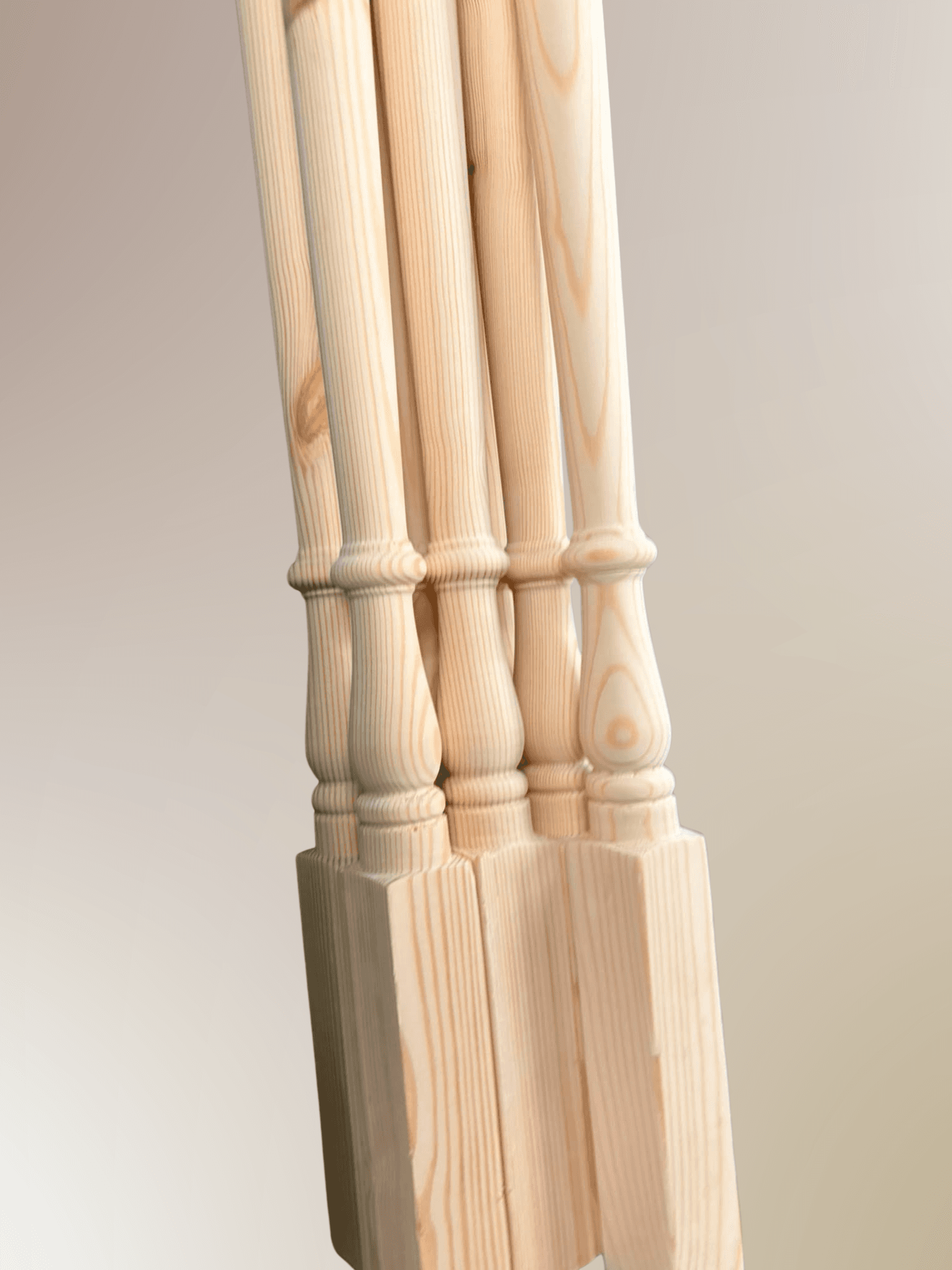 Full angled profile of turned pine baluster spindles showing square foot block, turned vase section and long straight shaft